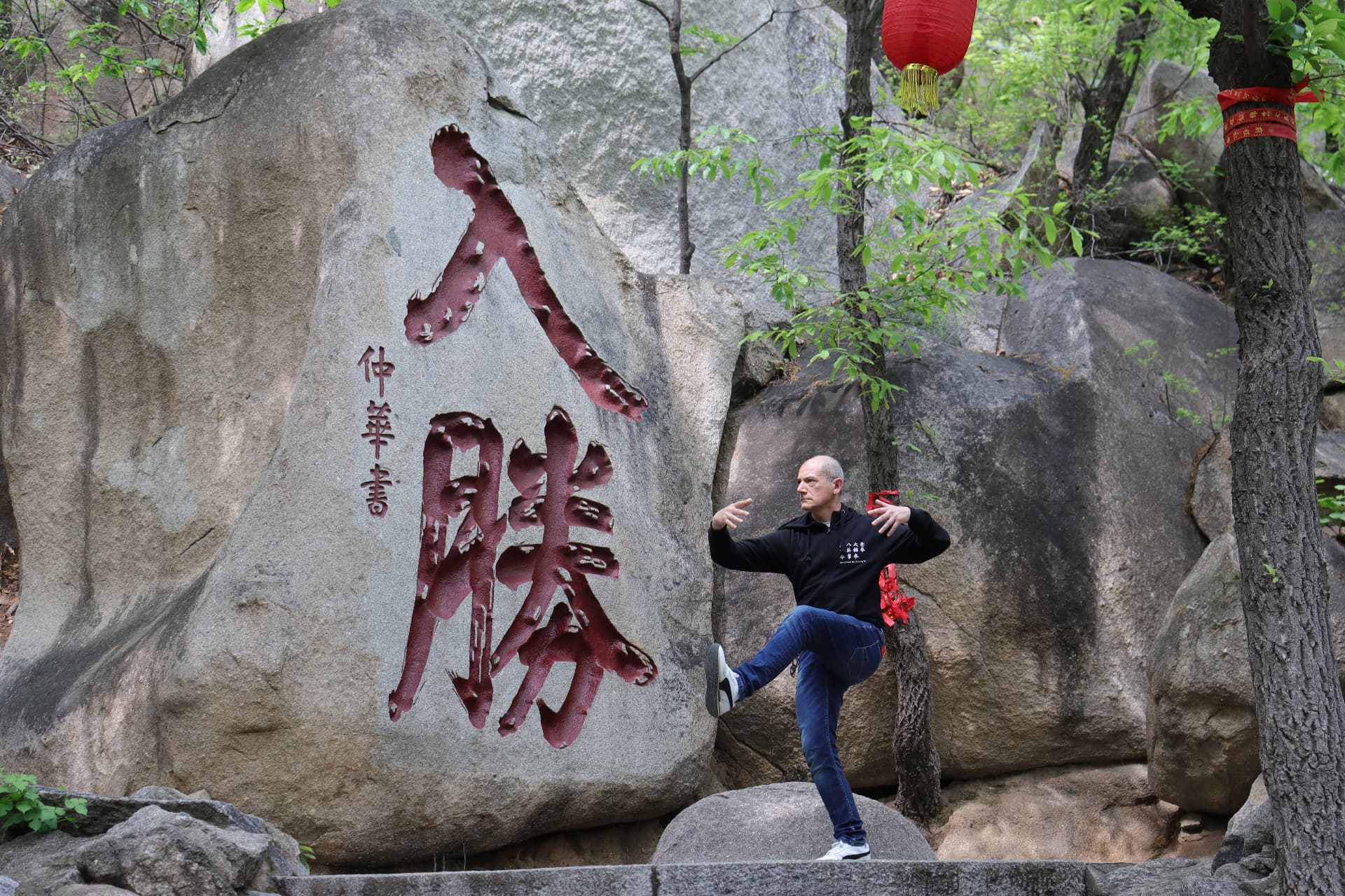Il M° Antonio Gentile in equilibrio davanti alla roccia incisa in Cina