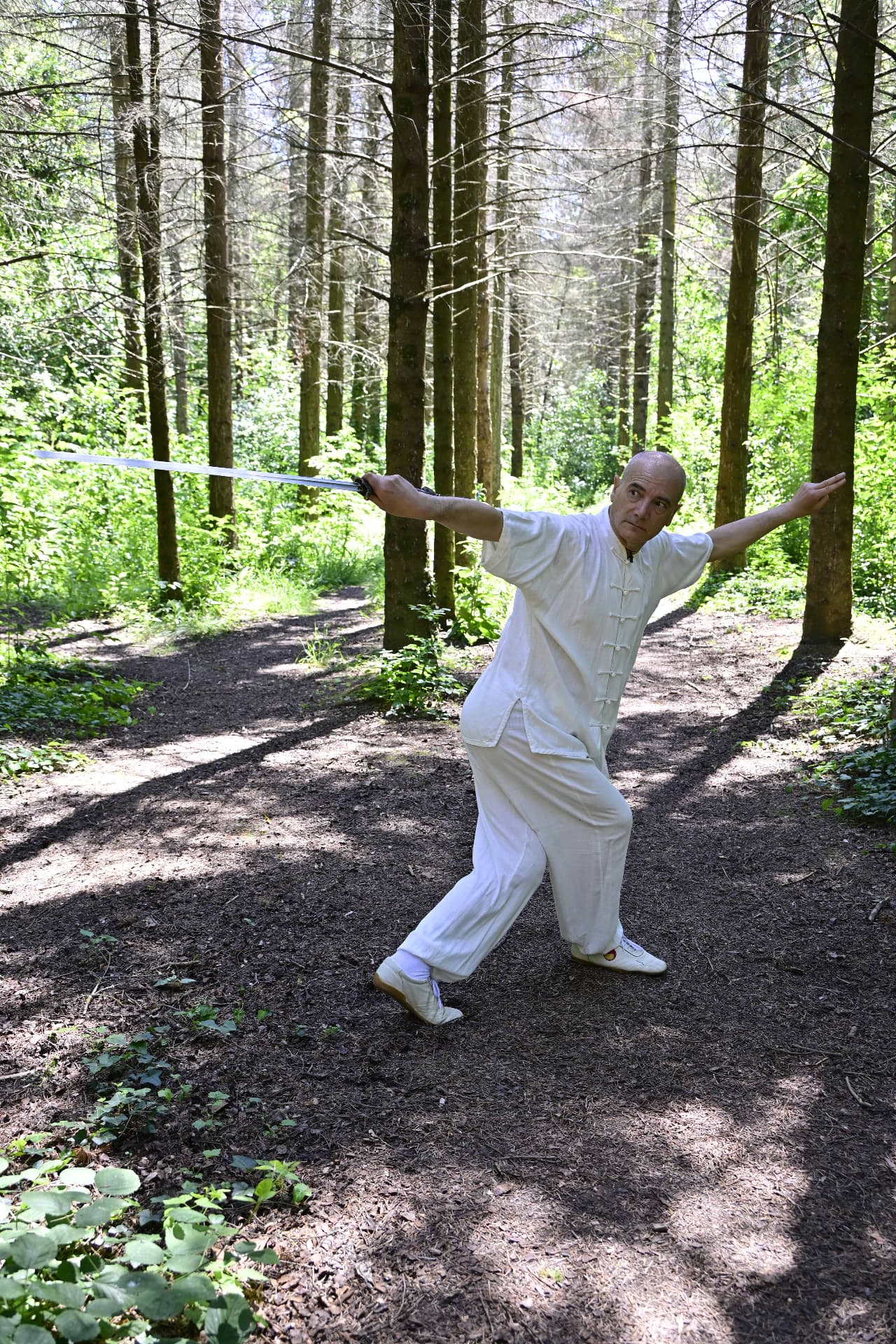 Il M° Antonio Gentile in torsione con la spada nel bosco
